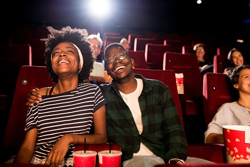 African-American couple on a date watching a movie at the cinema