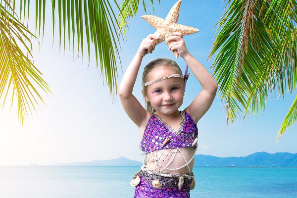 little girl dressed as a mermaid holding starfish